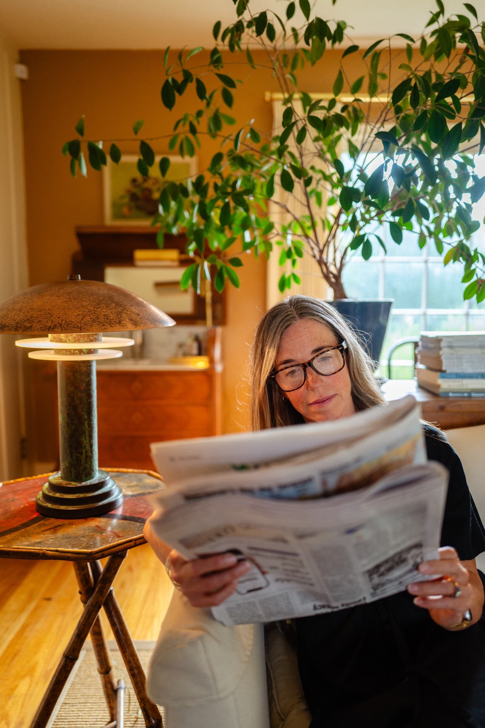 Woman reading The Columbian in living room